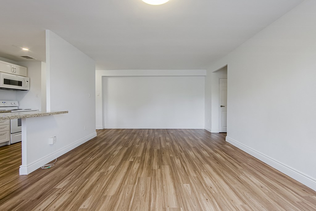 an empty living room with white walls and wood flooring at 161 St. George, Toronto