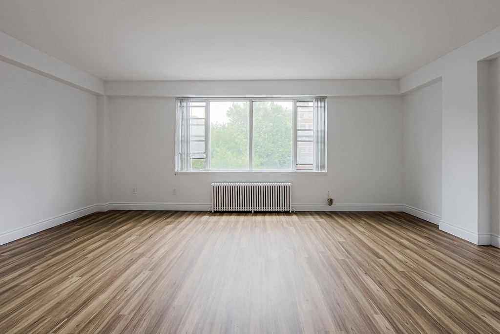 the living room of an empty house with wood floors and a window at 161 St. George, Toronto, CA