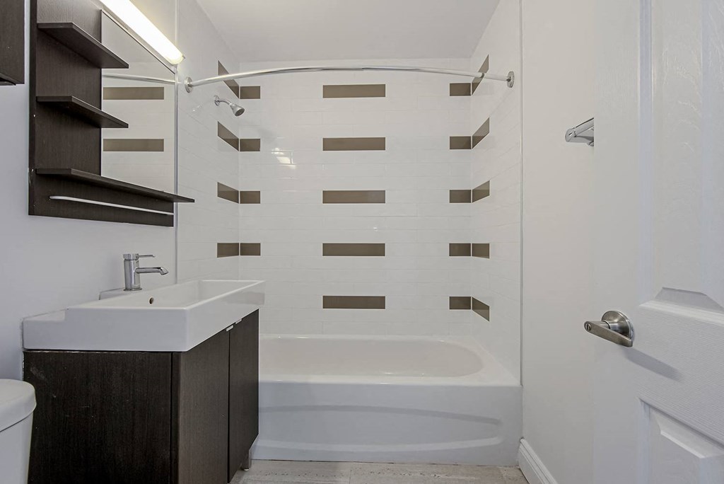 a white bathroom with a tub and a sink at 161 St. George, Canada, M5R 2M3