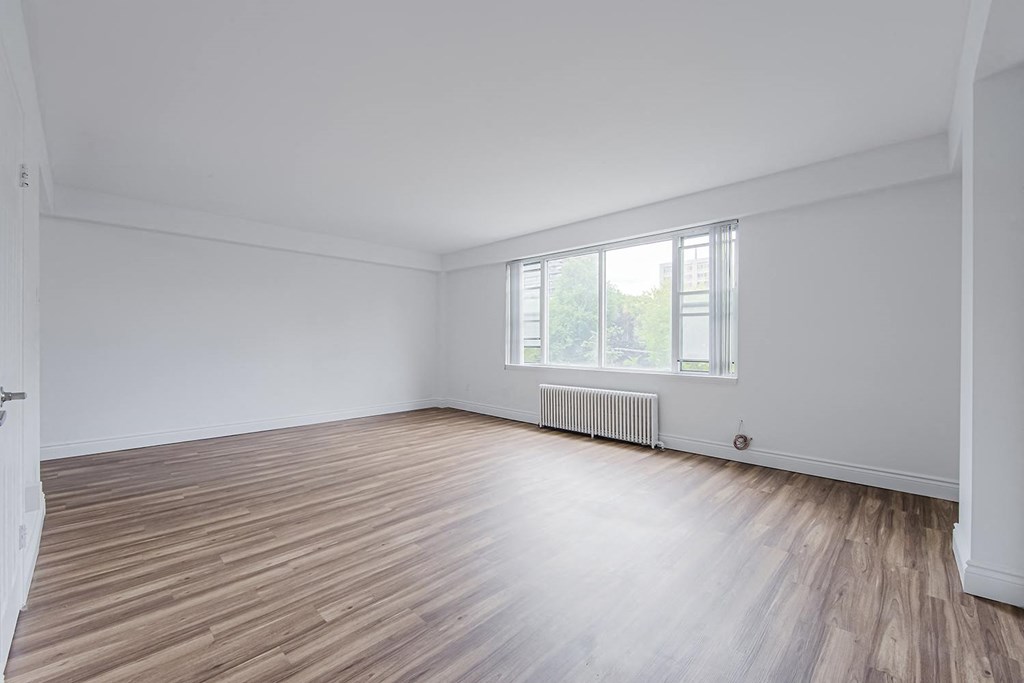 an empty room with wooden floors and a window at 161 St. George, Toronto, CA M5R 2M3