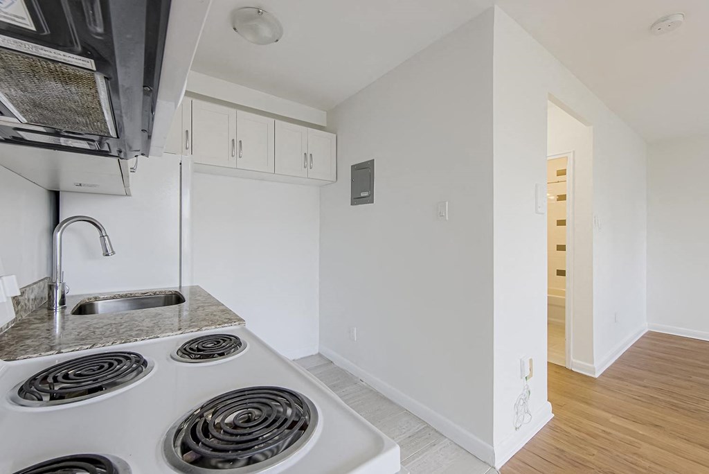a kitchen with white cabinets and a stove and a sink at 161 St. George, Toronto, CA M5R 2M3