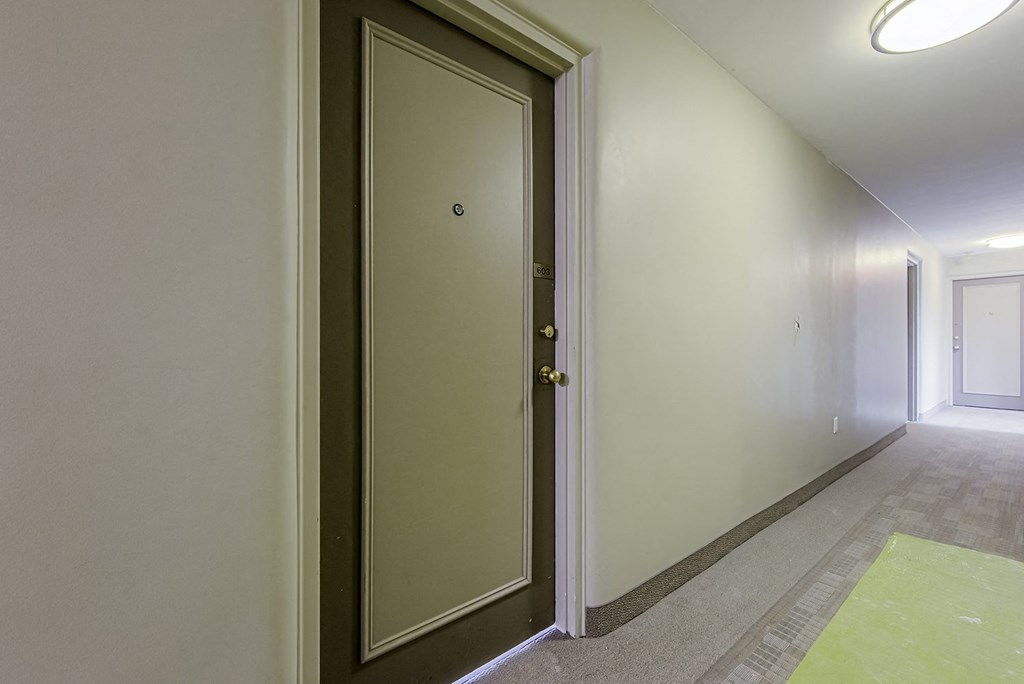 a door in a hallway of a building with white walls and a carpeted floor at 161 St. George, Toronto CA