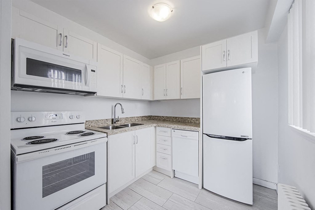 a white kitchen with white appliances and white cabinets at 161 St. George, Toronto Canada