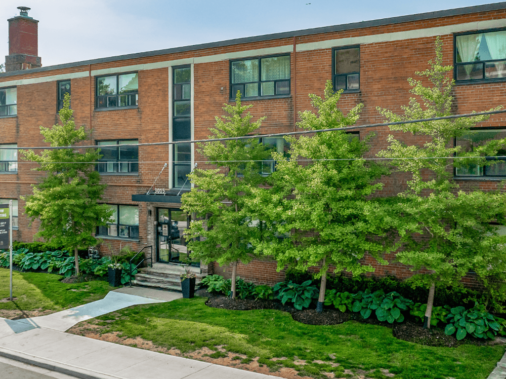 A brick building with a green lawn in front.