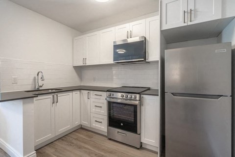 a kitchen with stainless steel appliances and white cabinets