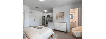 A bedroom with a bed, a chair, and a painting on the wall. at 608 Church Apartments, Toronto, ON