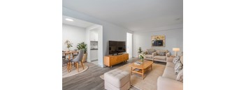A modern living room with a grey sofa, a wooden coffee table, and a television. at 161 St. George, Toronto, CA