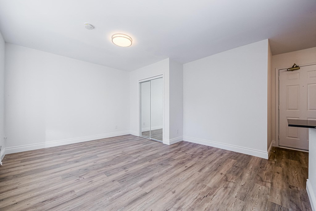 A room with a wooden floor and a white door. at 608 Church Apartments, Toronto, Ontario