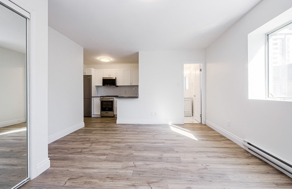 A spacious room with wooden flooring and white walls at 608 Church Apartments, Ontario