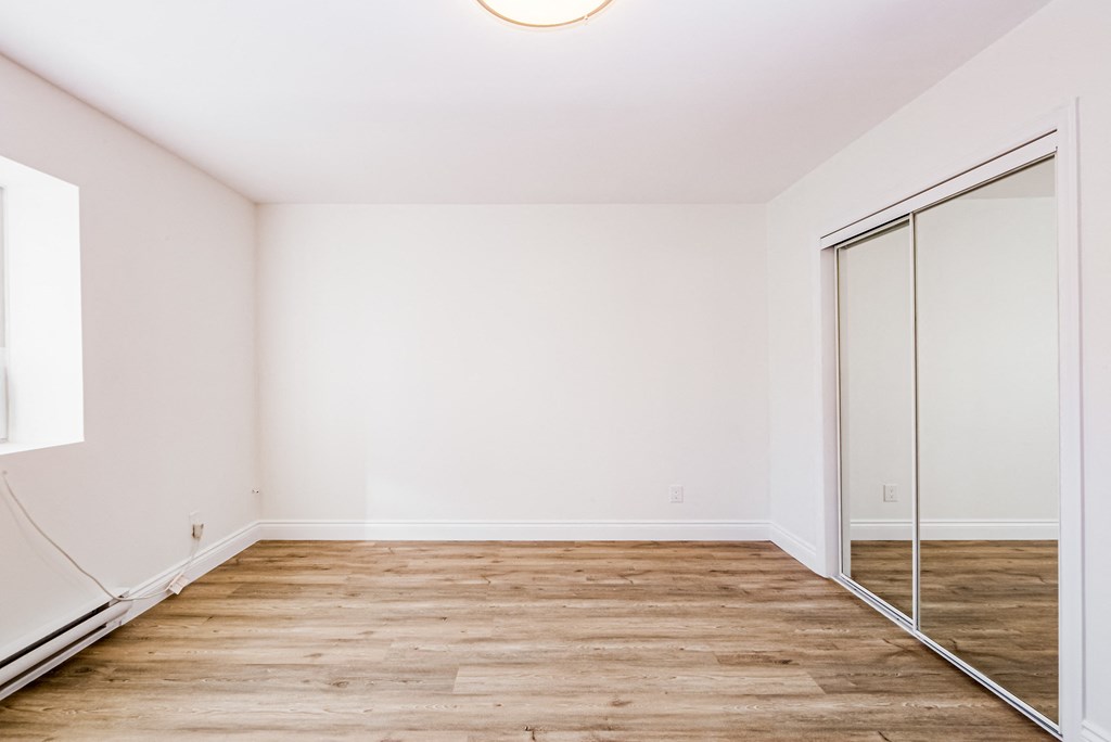 an empty room with white walls and mirrored closet doors at 608 Church Apartments, Ontario, M4Y 2E7