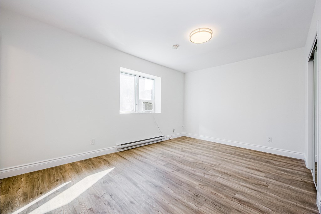 a living room with white walls and wooden floors and a window at 608 Church Apartments, Ontario, M4Y 2E7