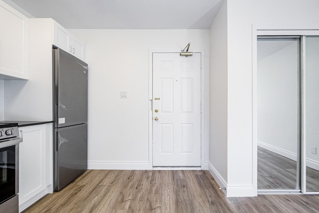 a kitchen with a white door and a stainless steel refrigerator at 608 Church Apartments, Toronto, ON, M4Y 2E7