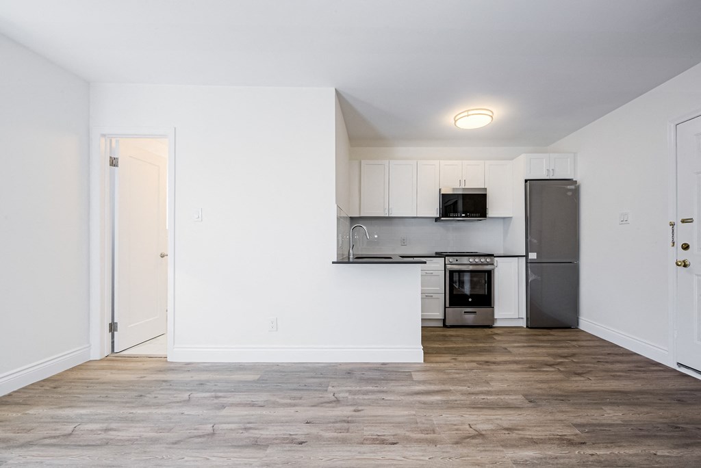 a kitchen with white walls and a stainless steel refrigerator at 608 Church Apartments, Toronto, ON, M4Y 2E7