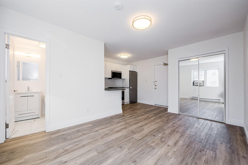 an empty living room with white walls and wood flooring at 608 Church Apartments, Ontario