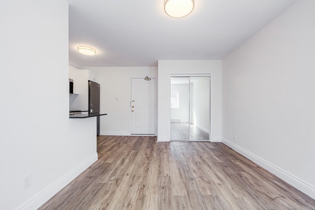 an empty living room with white walls and wood flooring at 608 Church Apartments, Toronto, Ontario