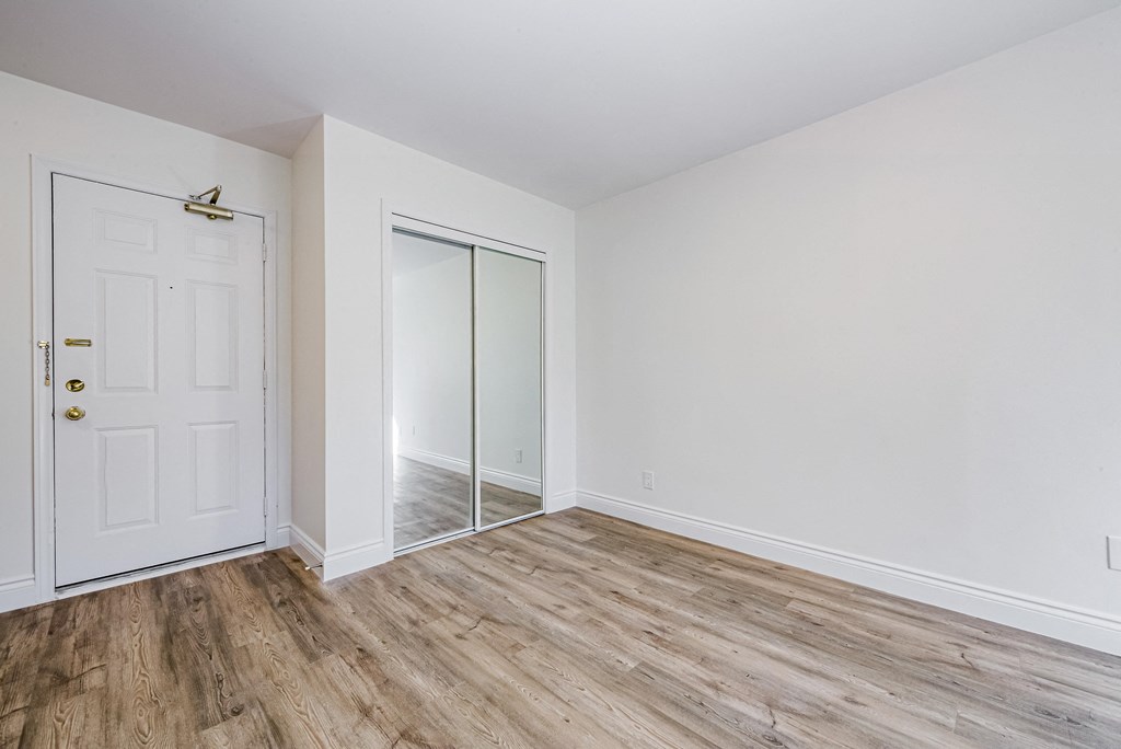 an empty room with white walls and a door to a closet at 608 Church Apartments, Toronto