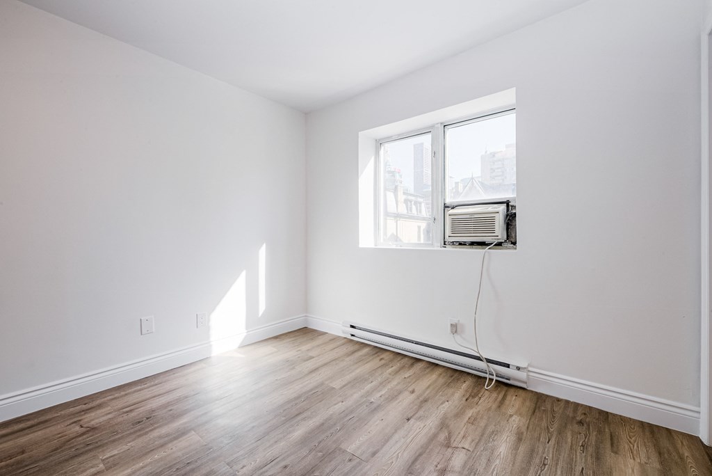 A room with a window and wooden flooring at 608 Church Apartments, Toronto