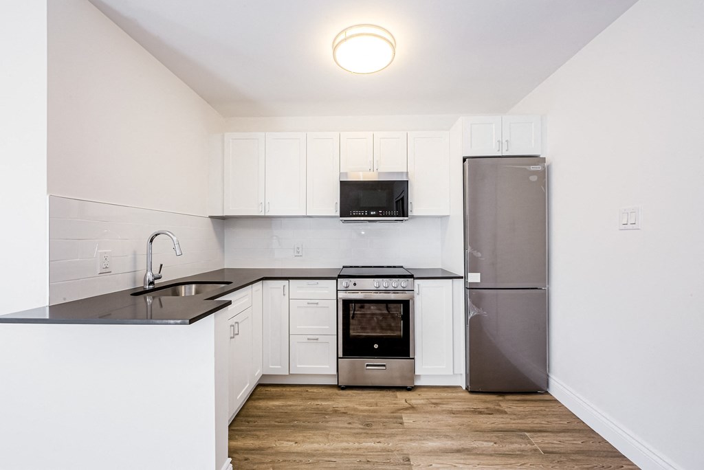 a kitchen with white cabinets and a stainless steel refrigerator at 608 Church Apartments, Ontario