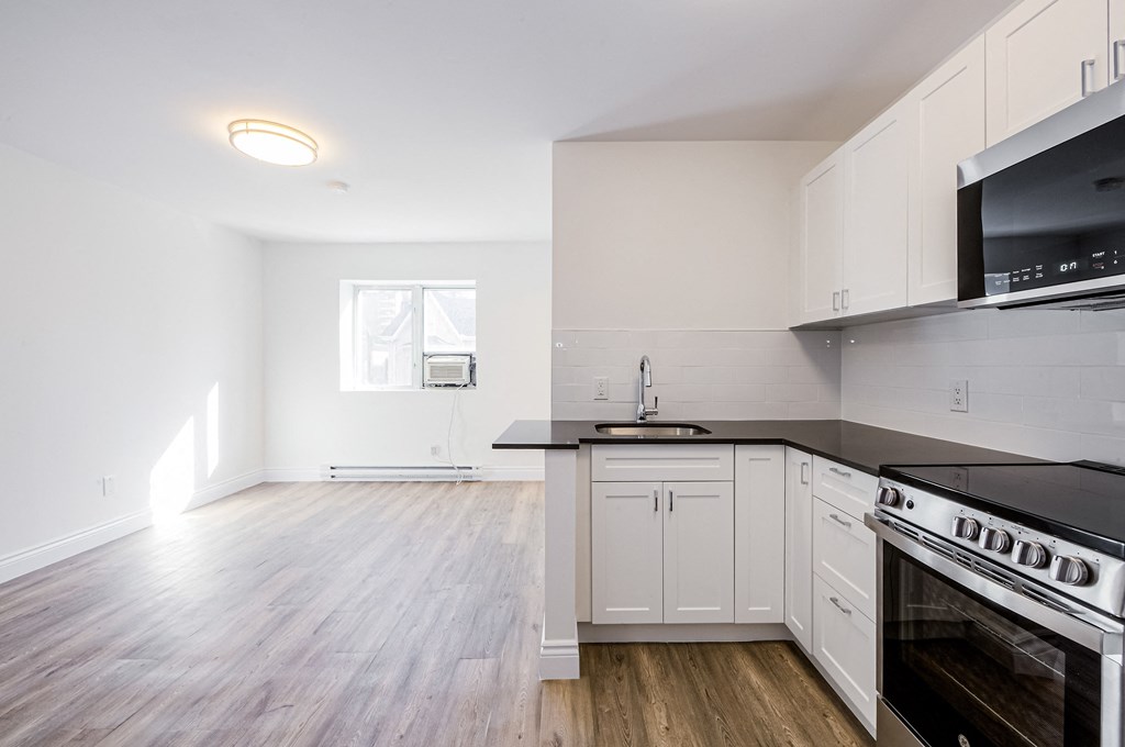 A kitchen with a stove top oven and a microwave at 608 Church Apartments, Toronto, Ontario
