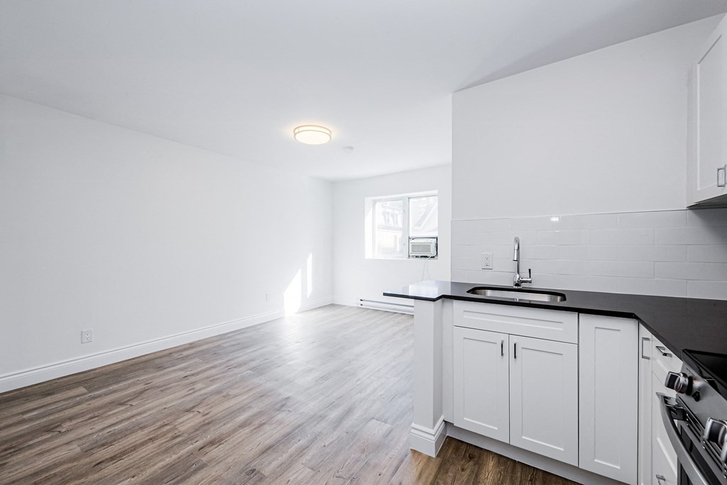 A kitchen with white cabinets and a black countertop at 608 Church Apartments, Ontario, M4Y 2E7
