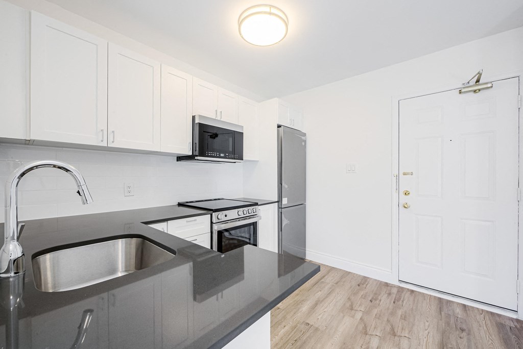 A kitchen with a sink, microwave, and oven at 608 Church Apartments, Ontario, M4Y 2E7