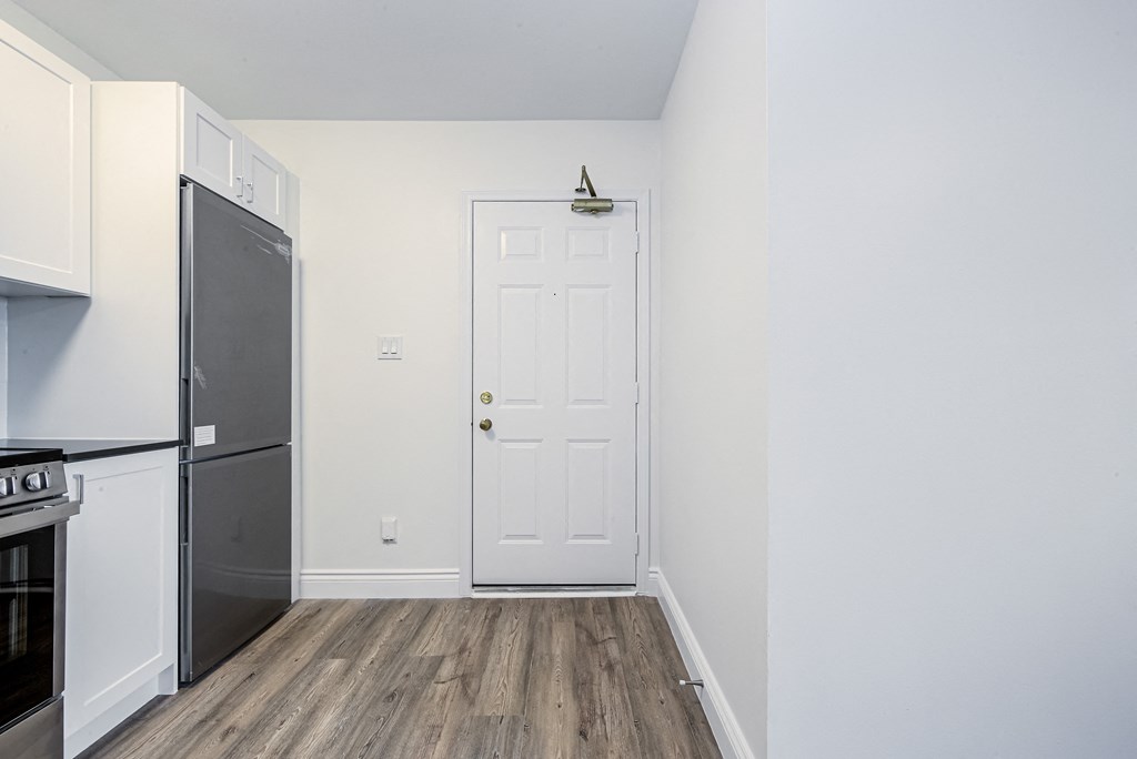 A kitchen with a black fridge and stove and a white door at 608 Church Apartments, Toronto, M4Y 2E7