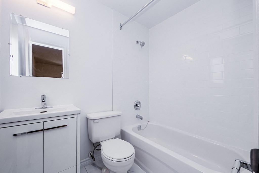 A white bathroom with a toilet, sink, and bathtub. at 608 Church Apartments, Ontario, M4Y 2E7