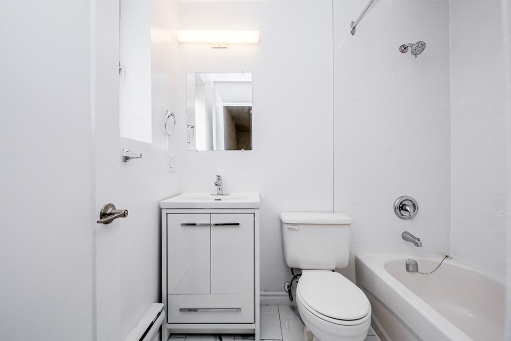 a white bathroom with a toilet sink and tub at 608 Church Apartments, Toronto, M4Y 2E7