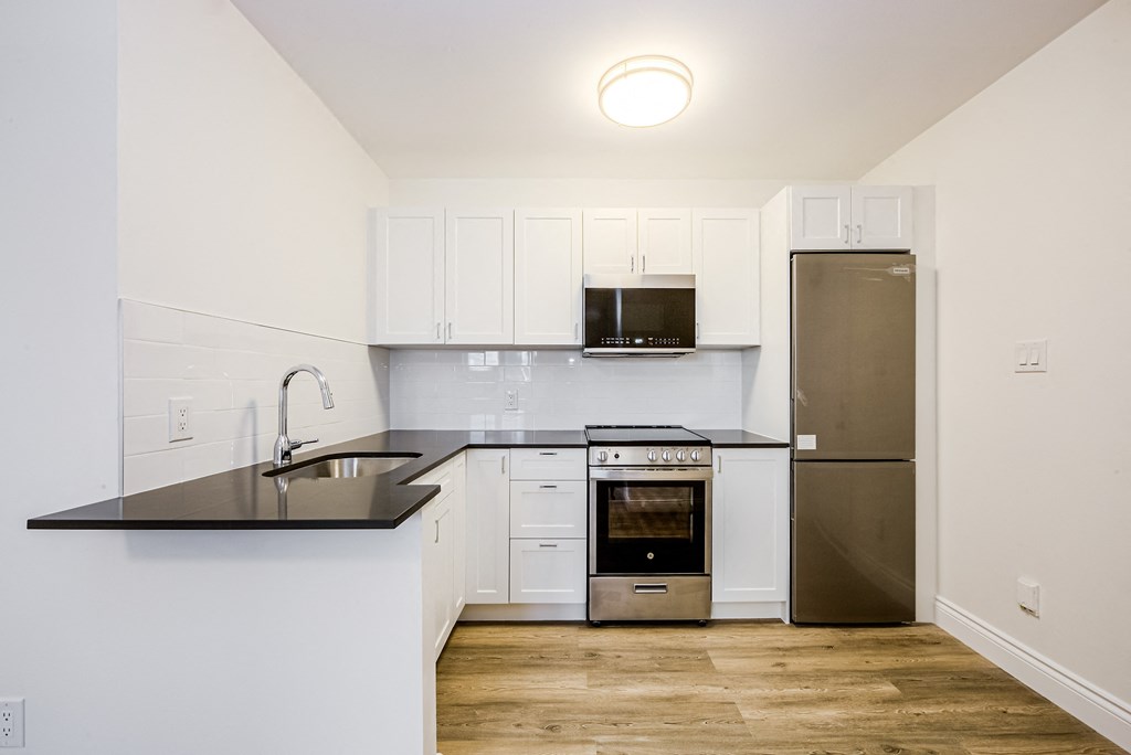 A kitchen with a black counter top and stainless steel appliances at 608 Church Apartments, Toronto, ON, M4Y 2E7