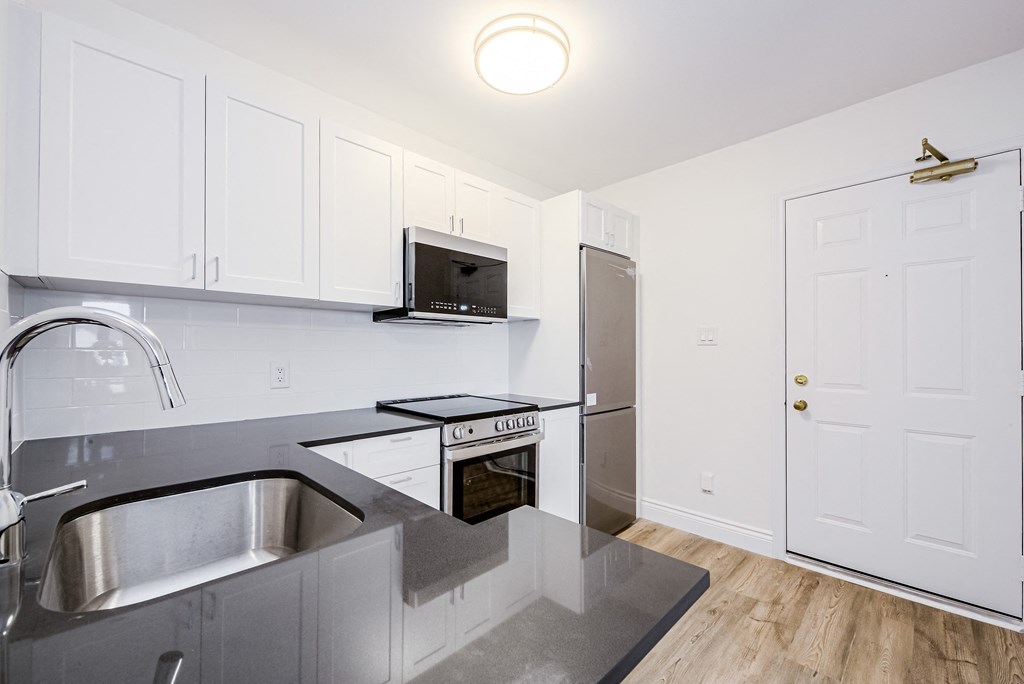 a kitchen with stainless steel appliances and white cabinets  at 608 Church Apartments, Toronto, ON, M4Y 2E7
