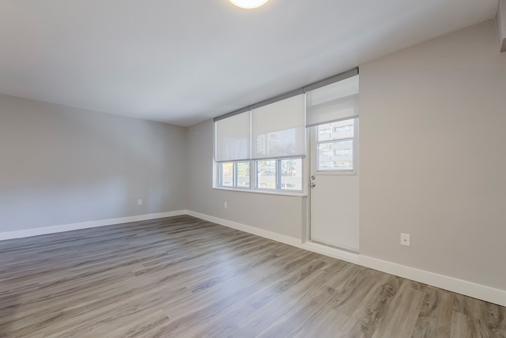 an empty living room with white walls and wood flooring at 70 Park, Mississauga, CA, L5G 1M5