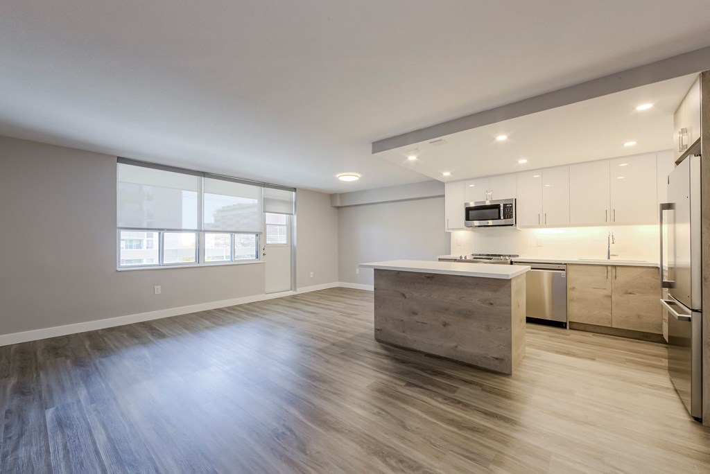 an empty living room with a kitchen with stainless steel appliances at 70 Park, Canada, L5G 1M5