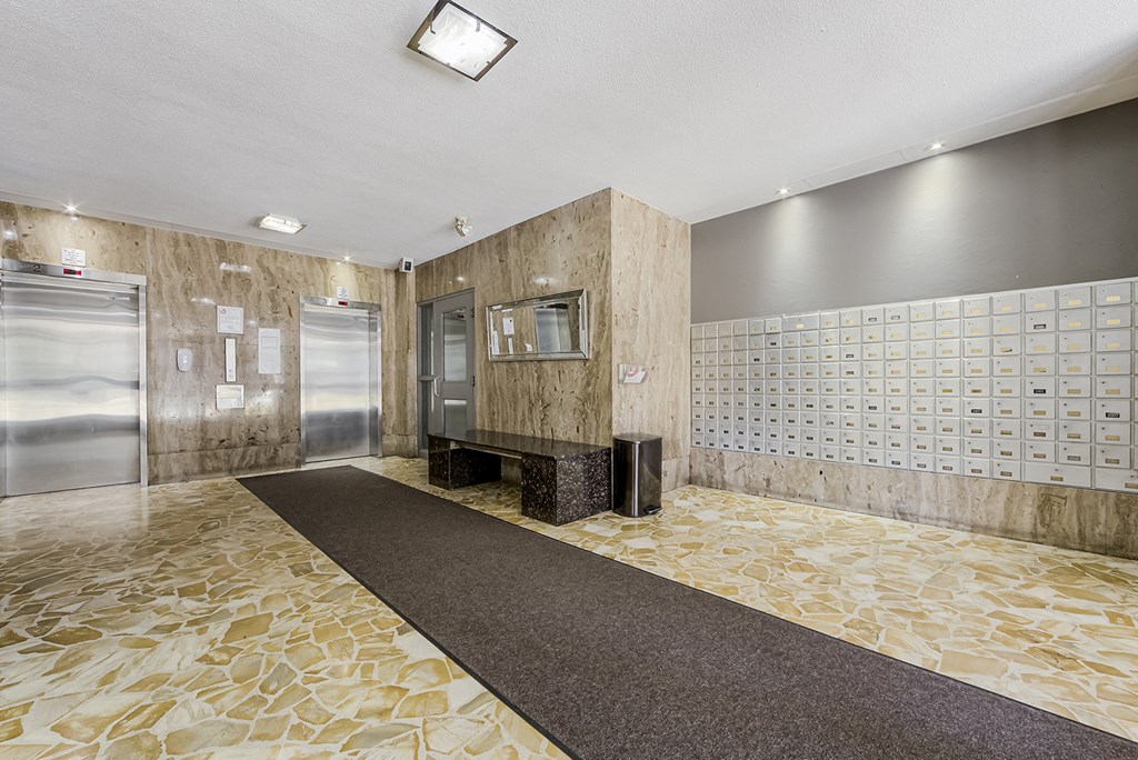 the lobby of a building with two refrigerators and a rug at 70 Park, Canada
