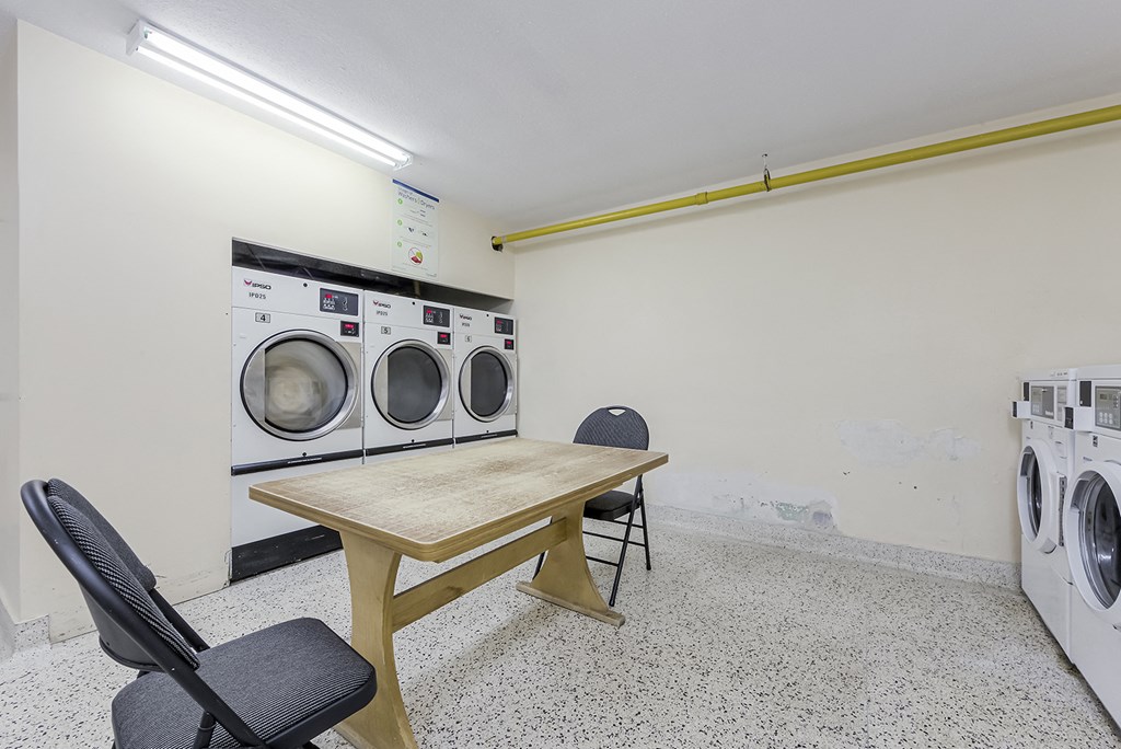 a laundry room with a table and chairs and washing machines at 70 Park, Canada, L5G 1M5