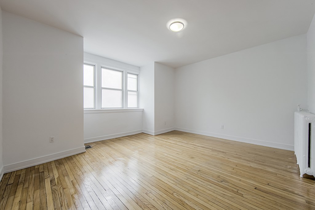 an empty room with white walls and wood floors at 723 Bloor Apartments, Canada