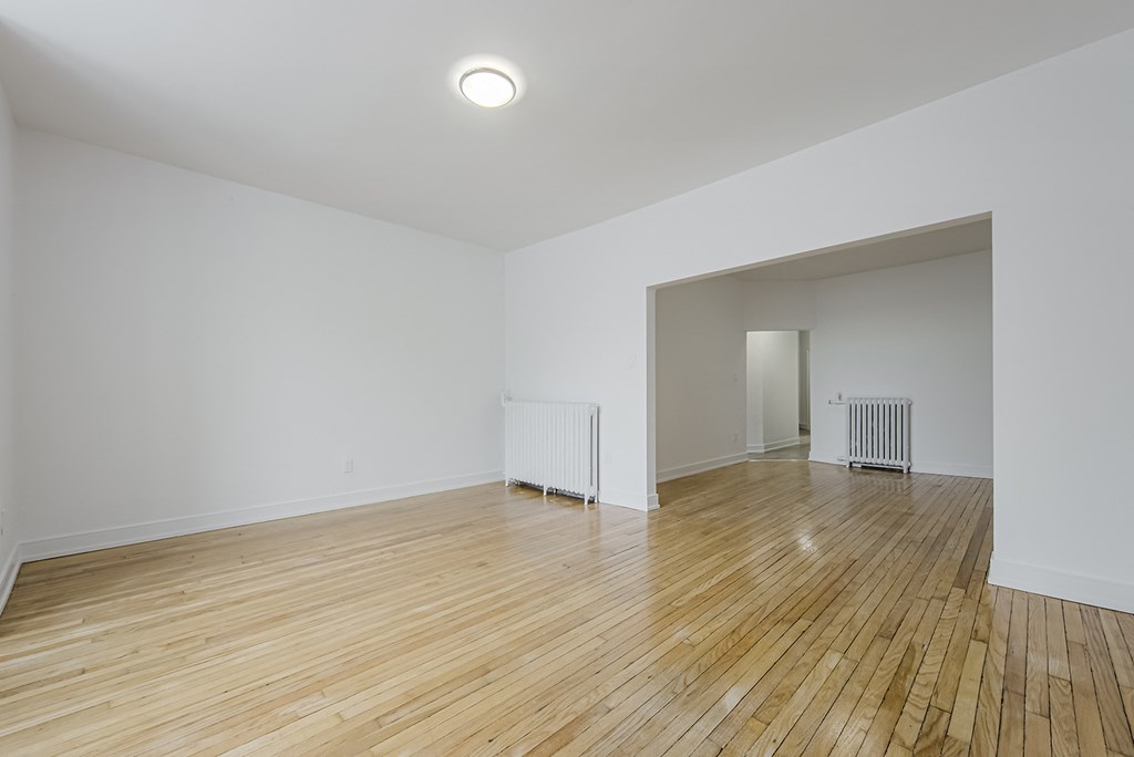 A room with wooden floors and white walls at 723 Bloor Apartments, Toronto, CA