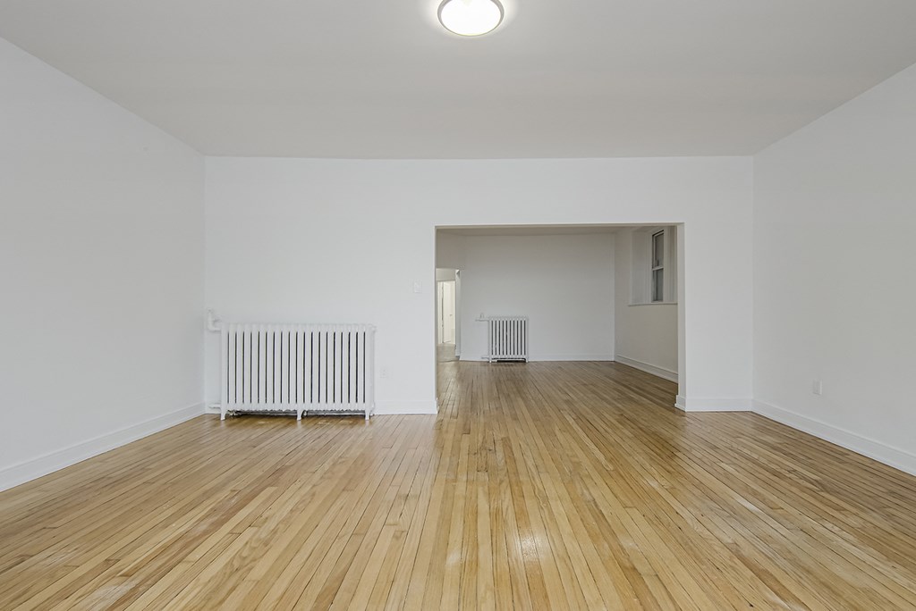 Living room with wood floors and white walls at 723 Bloor Apartments, Toronto