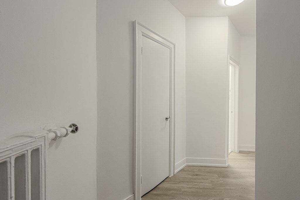 a room with white walls and a white door and a hallway at 723 Bloor Apartments, Canada