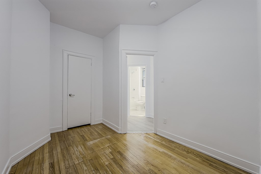 A room with a wooden floor and white walls at 723 Bloor Apartments, Toronto, CA