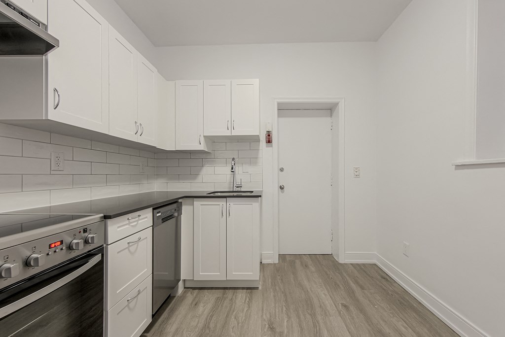A kitchen with white cabinets and a stainless steel oven at 723 Bloor Apartments, Toronto, Canada