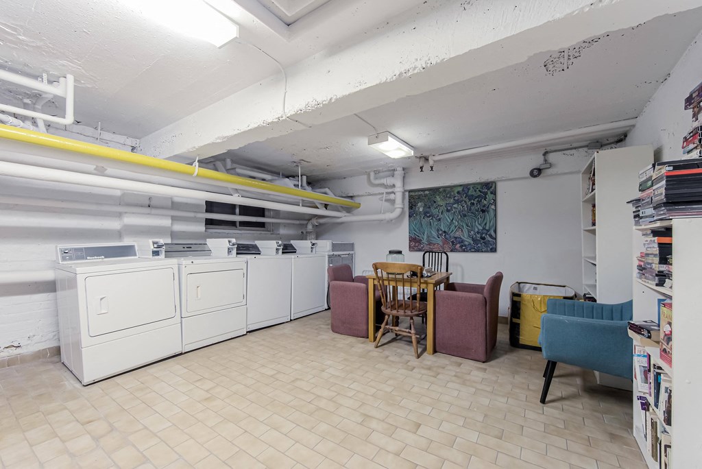 a laundry room with washing machines and a table and chairs