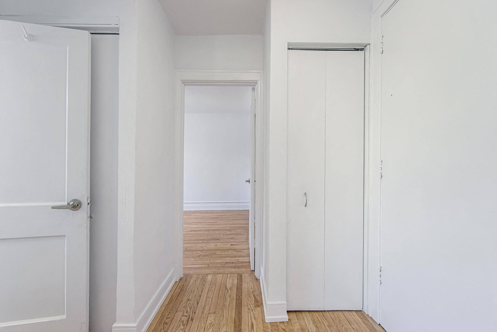an empty room with white walls and a wood floor