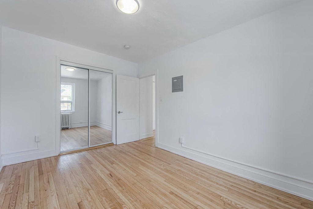 an empty living room with white walls and wood floors