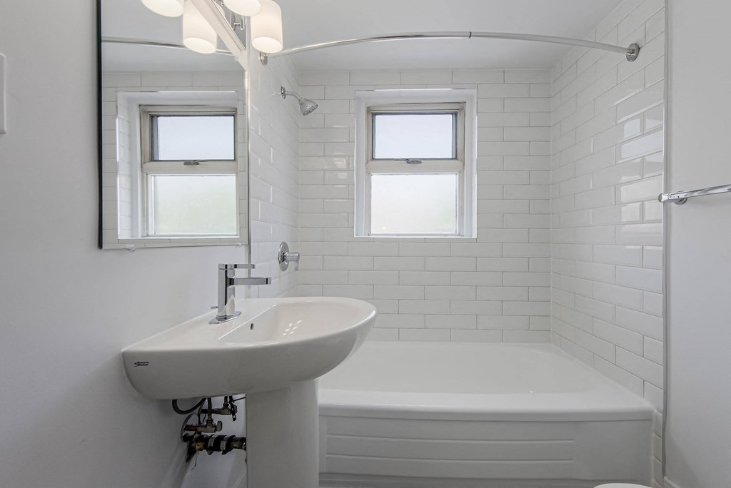 a small white bathroom with a sink and a tub