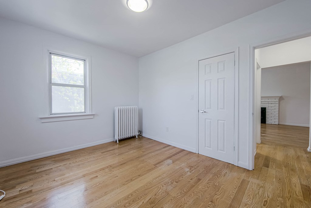 a living room with white walls and a white door and a window at 83-85 Silver Birch, Canada