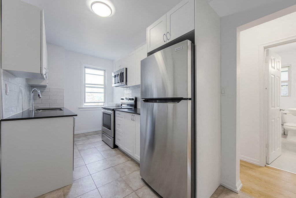 a kitchen with stainless steel appliances and white cabinets at 83-85 Silver Birch, Toronto, CA