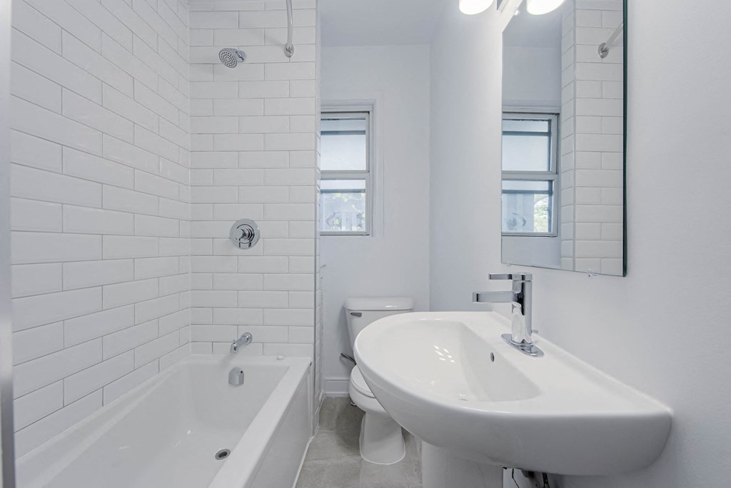 a white bathroom with a sink and a tub at 83-85 Silver Birch, Canada, M4E 3L2