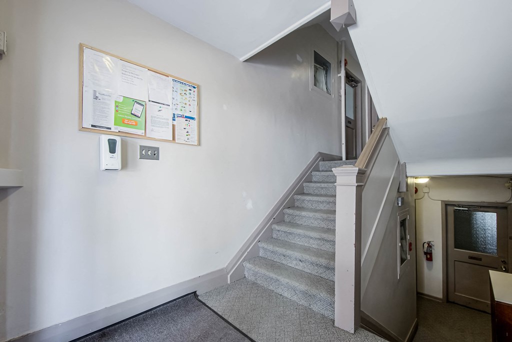 a stairwell in a building with white walls and a staircase with a door at 83-85 Silver Birch, Toronto