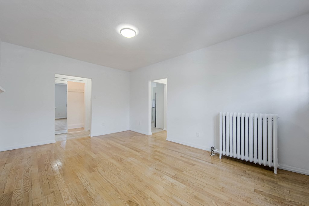 a living room with white walls and a radiator at 83-85 Silver Birch, Toronto, M4E 3L2