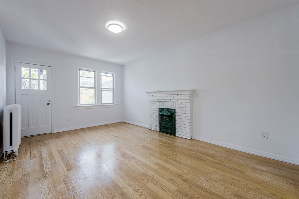 an empty room with white walls and a wood floor at 83-85 Silver Birch, Toronto, M4E 3L2
